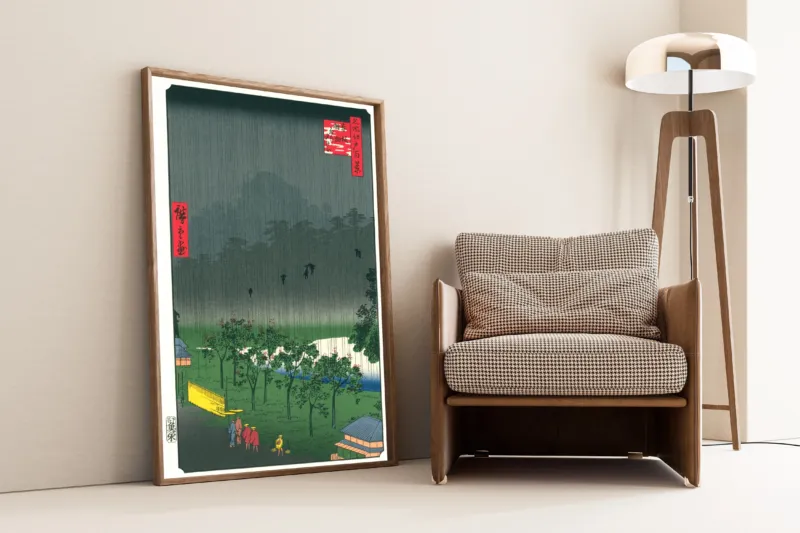 View of the Paulownia Imperiales Trees at Akasaka on a Rainy Evening by Utagawa Hiroshige — framed and leaning against a wall beside an armchair and a floor